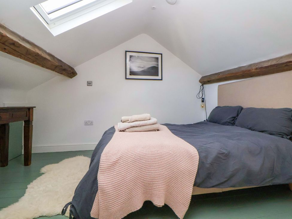 A bedroom with a bed and table at Cwtch in Mold