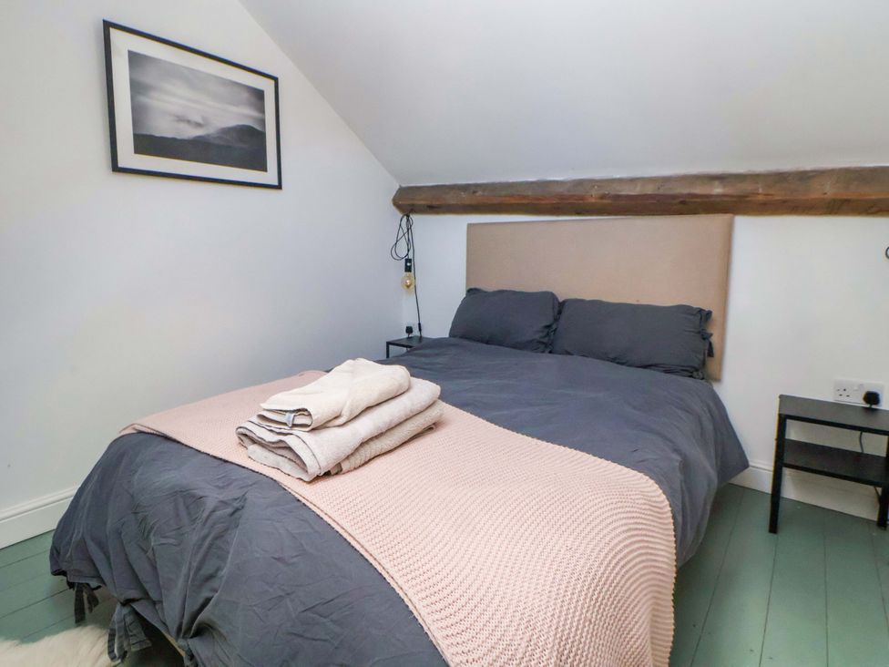 A bedroom with a bed and towels at Cwtch in Mold