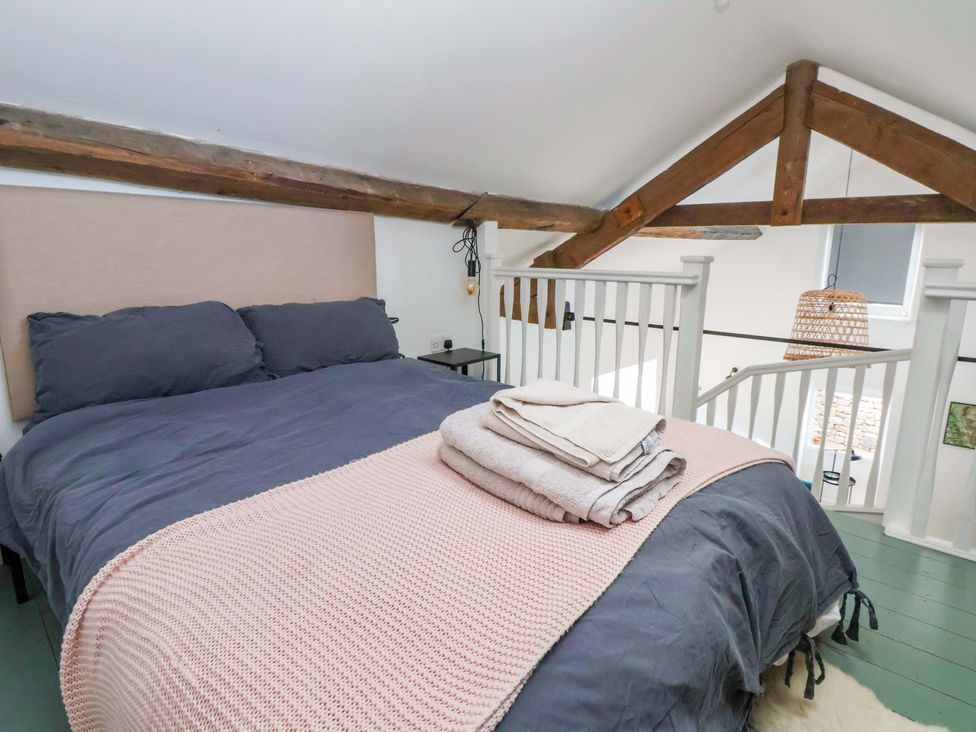 A bedroom with a bed and stairs at Cwtch in Mold