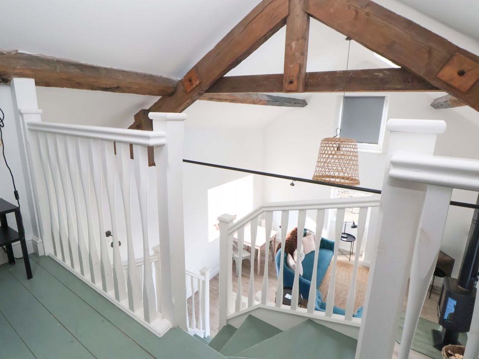 A staircase with white railing and wooden beams at Cwtch in Mold
