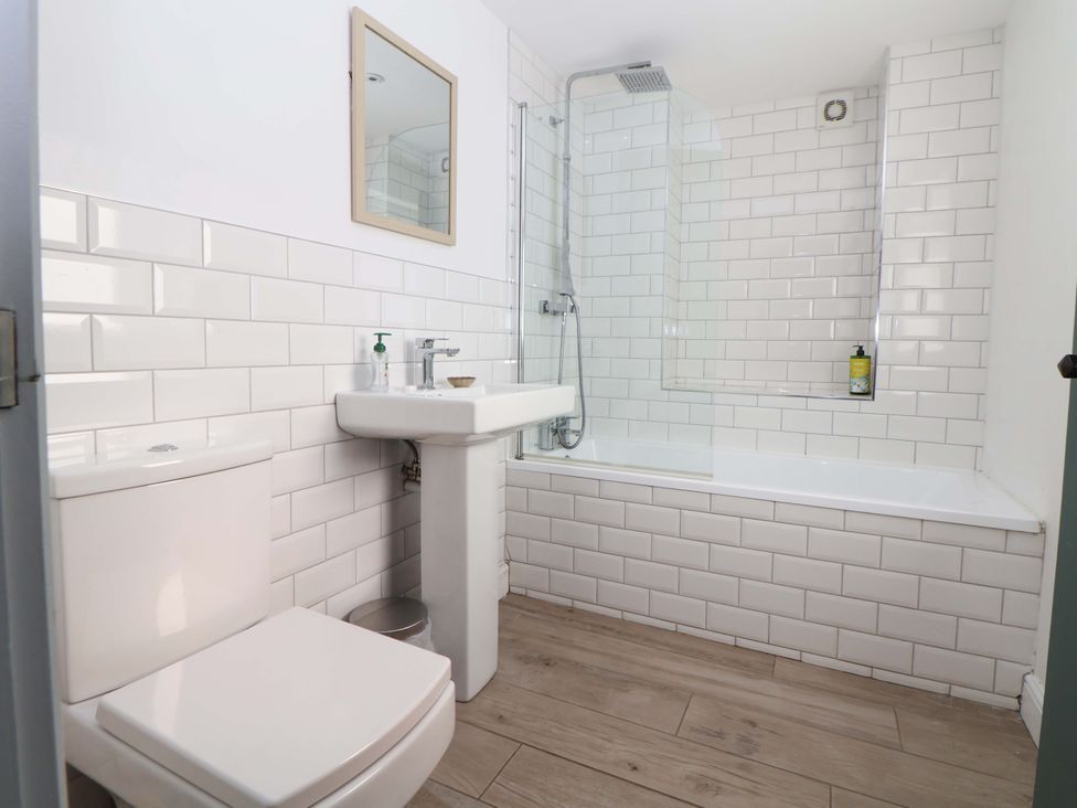 A bathroom with a sink, toilet, and shower at Cwtch Mold