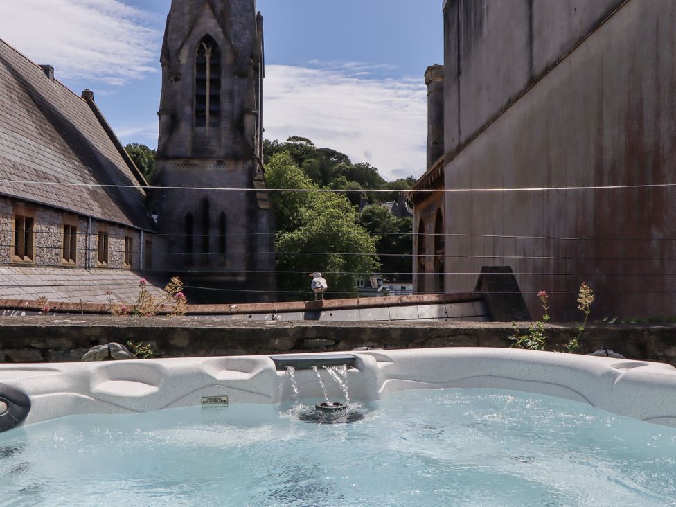 A hot tub with a view of a church and trees at Driftwood in Torquay