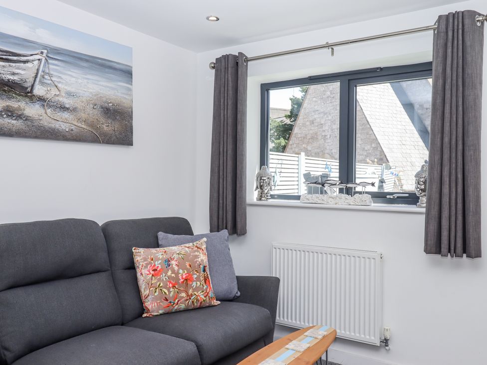 A living room with a sofa and window at Driftwood in Torquay