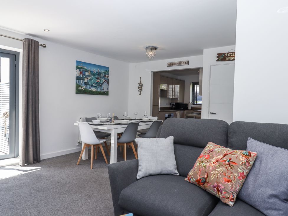 A living room with a sofa and dining area at Driftwood in Torquay