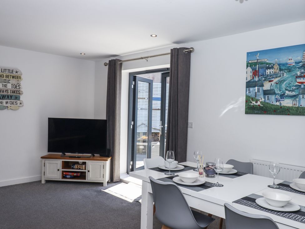 A dining room with a table and chairs at Driftwood in Torquay