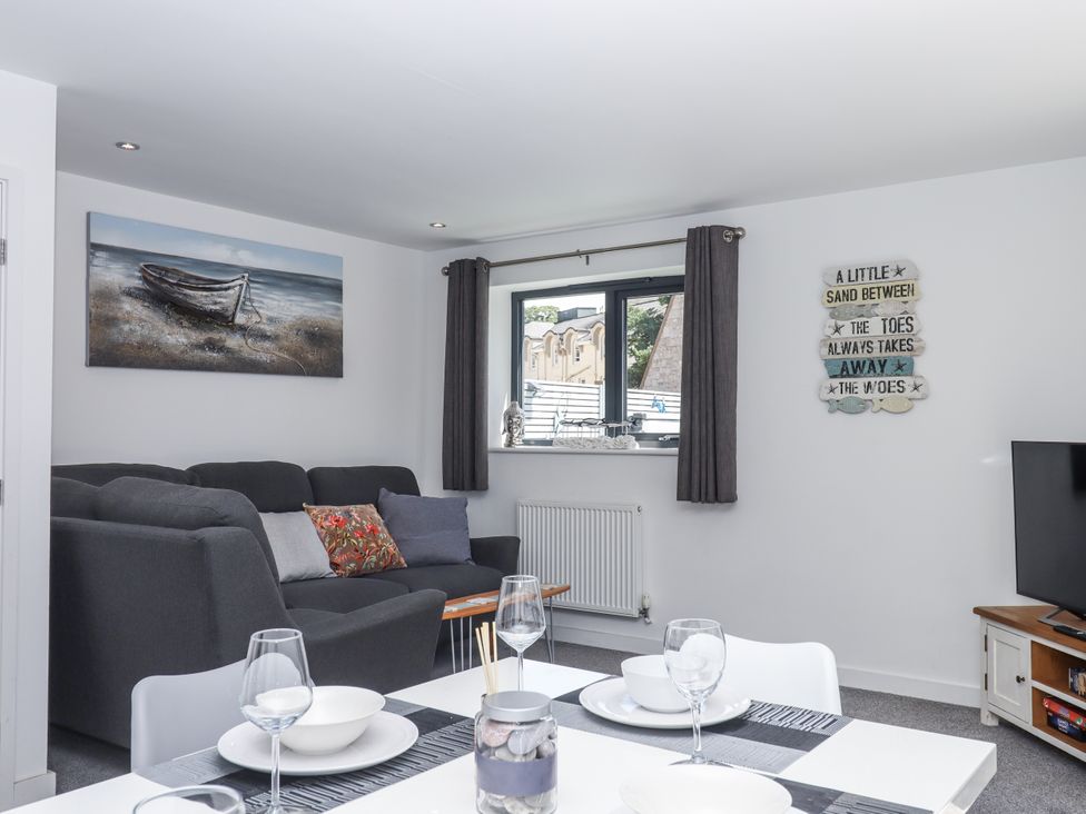 A living room with a sofa and a table at Driftwood in Torquay
