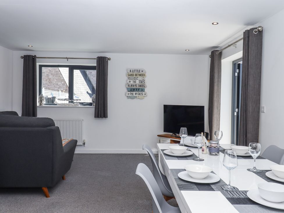 A dining room with a table set for meals at Driftwood in Torquay