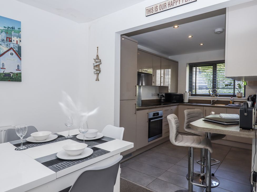 A kitchen with dining table and chairs at Driftwood in Torquay