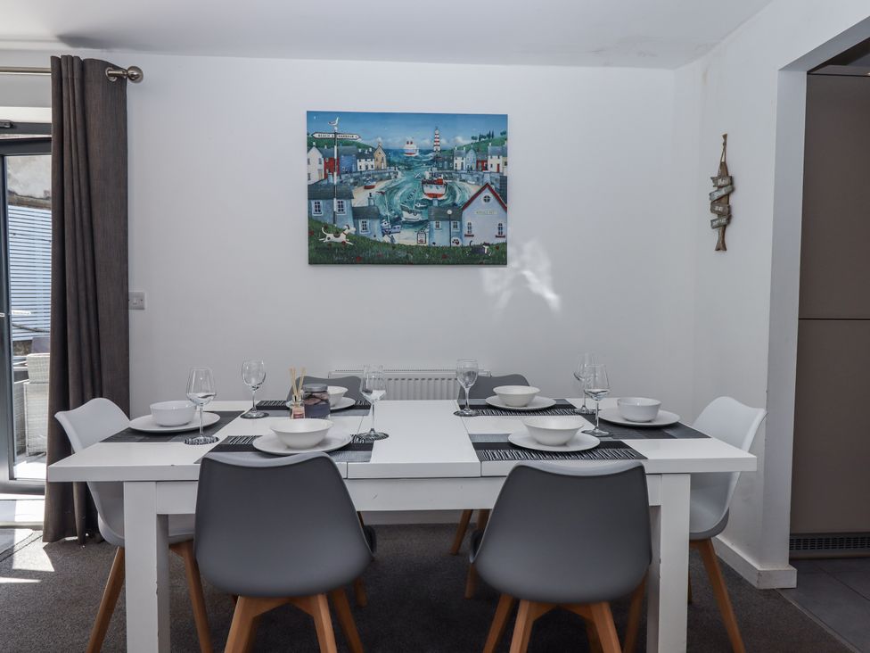A dining room with a table set for dinner at Driftwood in Torquay