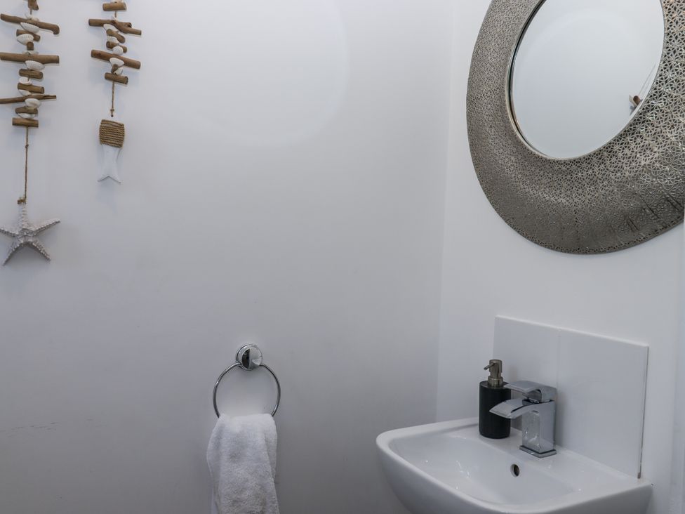 A bathroom with a washbasin and mirror at Driftwood in Torquay