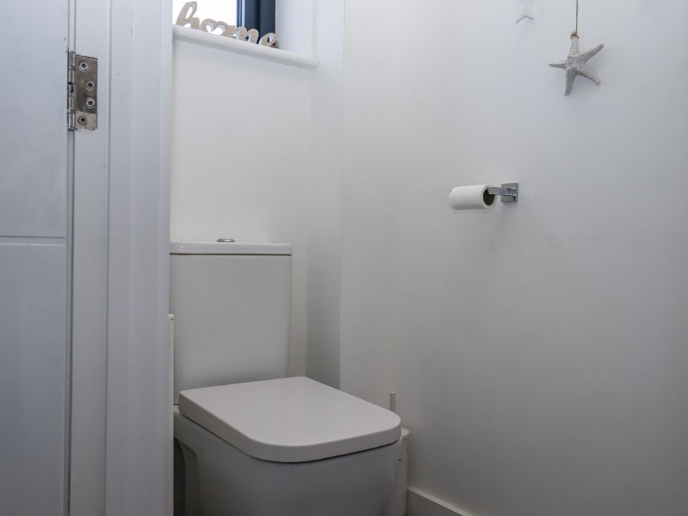 A bathroom with a toilet and toilet paper at Driftwood in Torquay