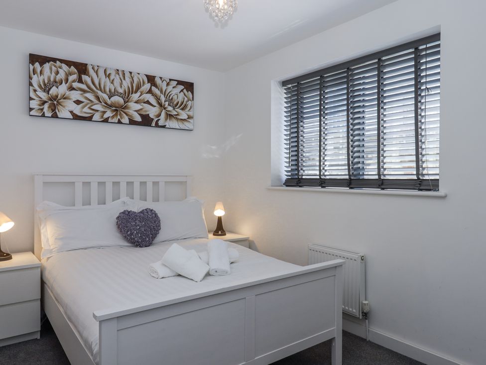 A bedroom with a bed and bedside tables at Driftwood in Torquay