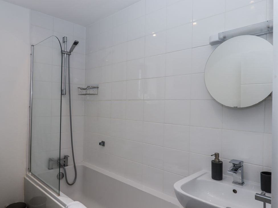 A bathroom with a bathtub and sink at Driftwood in Torquay