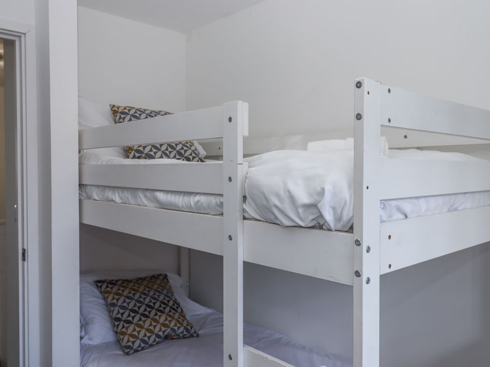 A bunk bed with pillows and blankets at Driftwood in Torquay