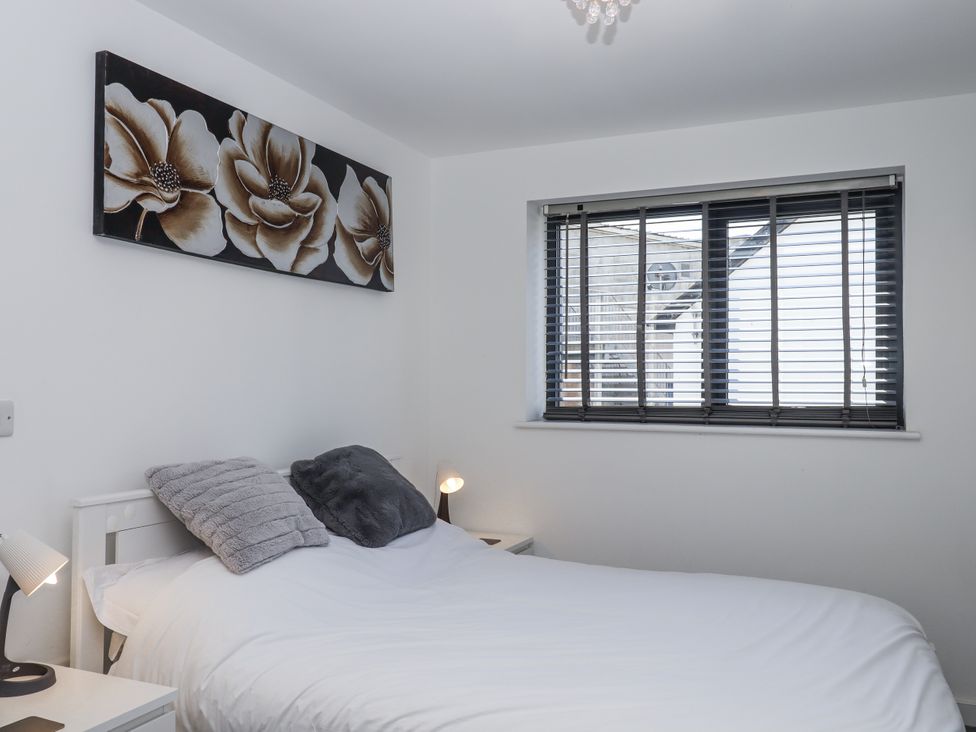 A bedroom with a bed and wall art at Driftwood in Torquay
