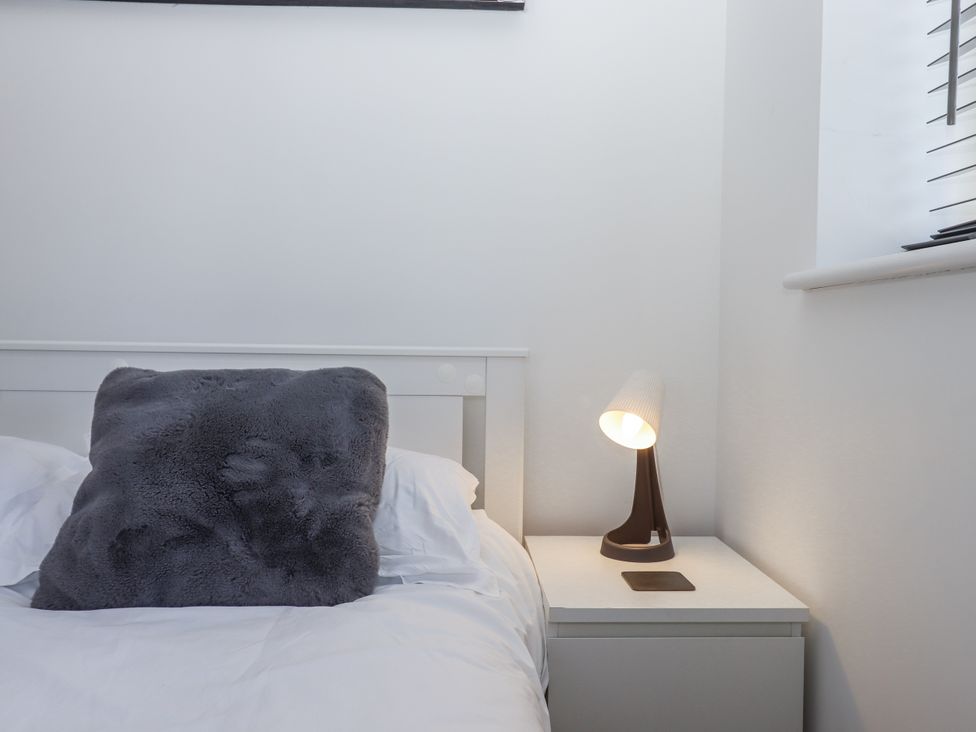 A bedroom with a bed and bedside table at Driftwood in Torquay