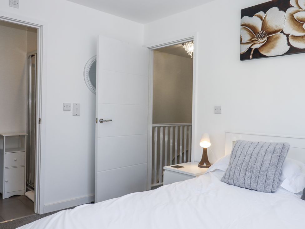 A bedroom with a bed and a bedside table at Driftwood in Torquay