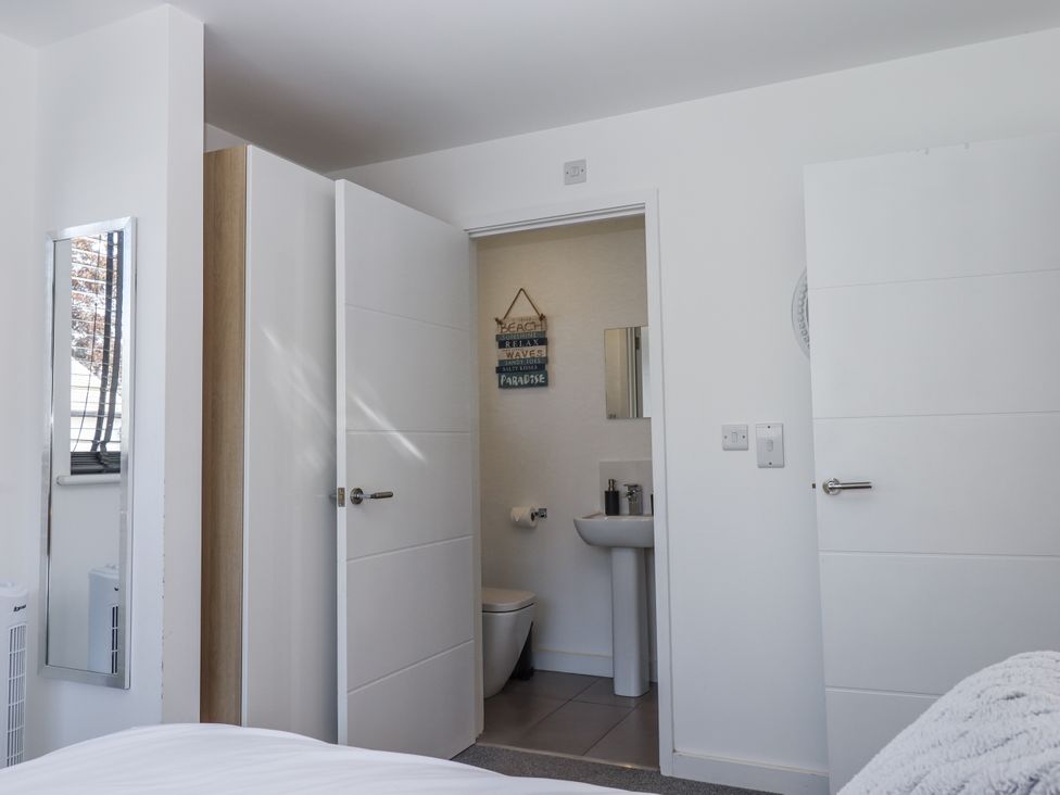 A bathroom with a toilet and sink at Driftwood in Torquay
