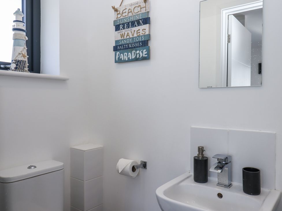A bathroom with a toilet and sink at Driftwood in Torquay
