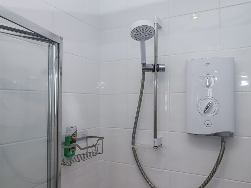 A shower with a heater and soap dispenser at Driftwood in Torquay