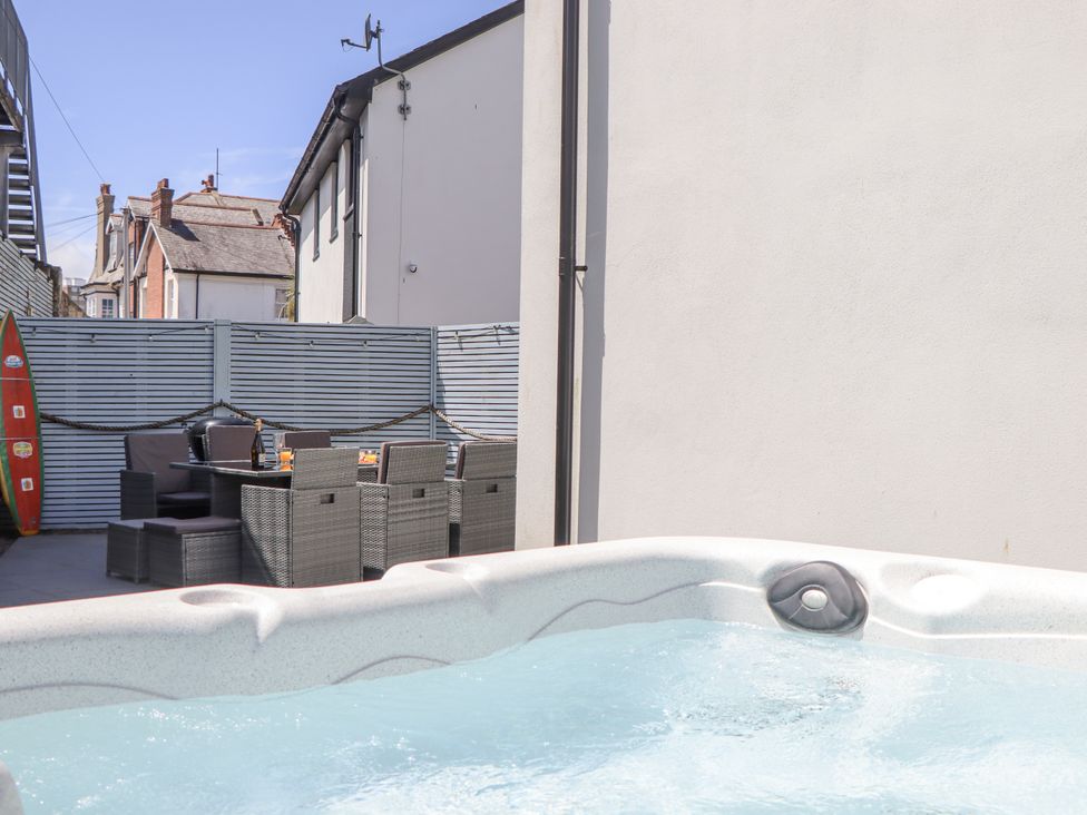An outdoor area with a hot tub and seating at Driftwood in Torquay