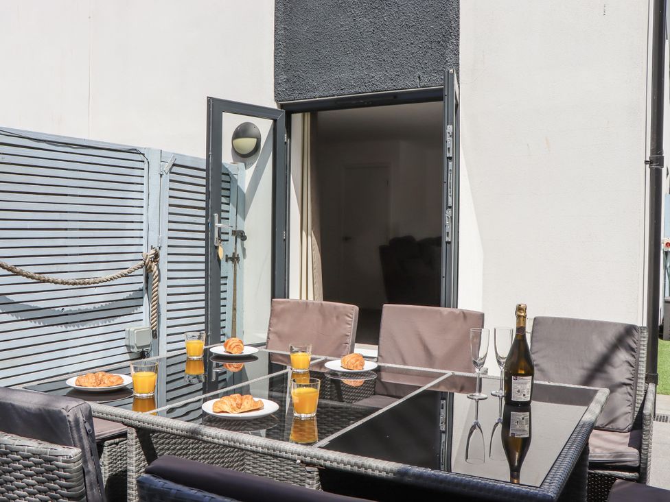 An outdoor dining area with a table and chairs at Driftwood in Torquay