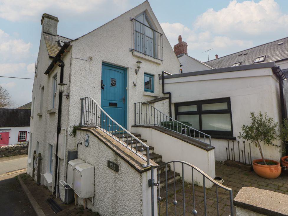 An exterior view of a house with stairs and a blue door at Awen Ingli Newport, Pembrokeshire