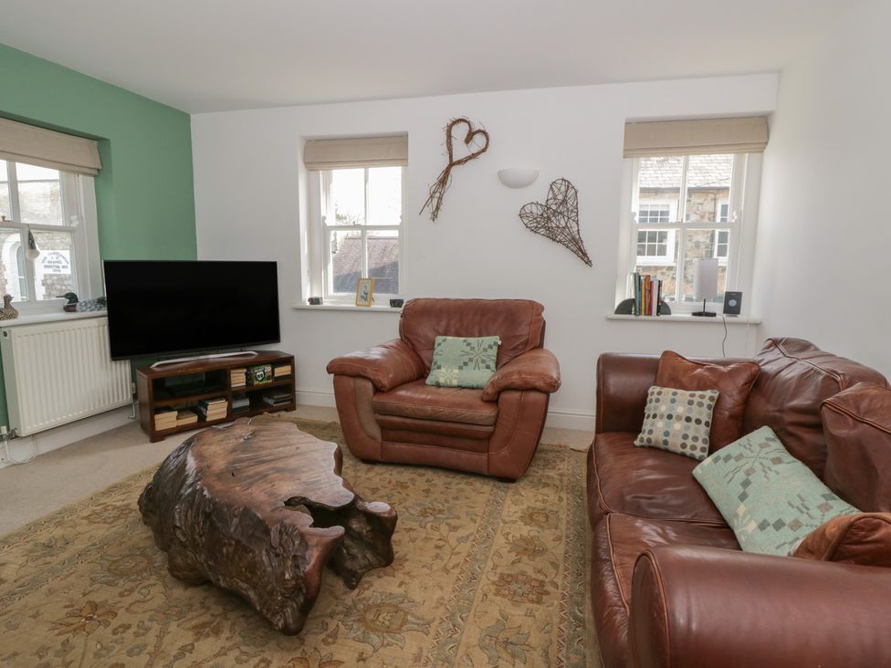 A living room with a television and sofas at Awen Ingli, Newport, Pembrokeshire