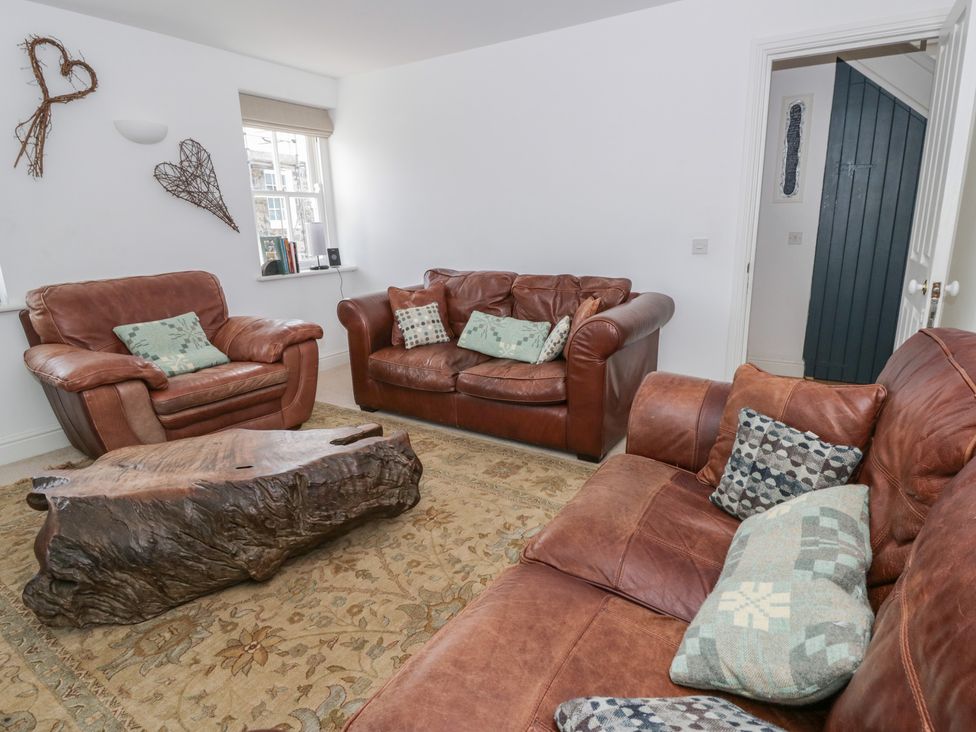 A living room with leather sofas and a wooden coffee table at Awen Ingli Newport, Pembrokeshire