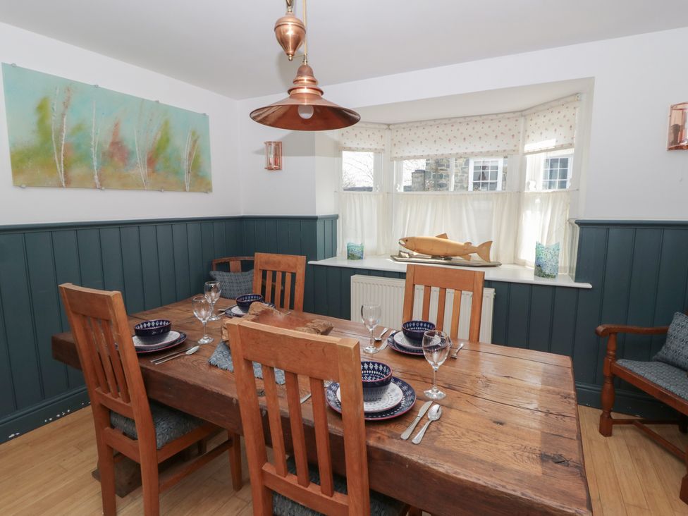 A dining room with a wooden table and chairs at Awen Ingli in Newport, Pembrokeshire