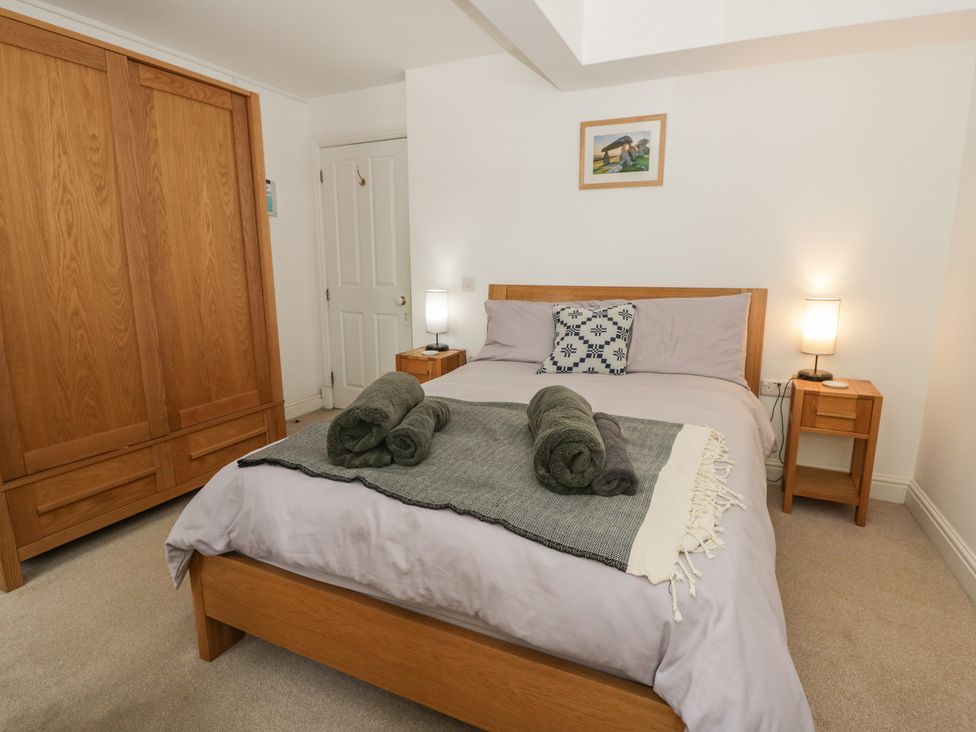 A bedroom with a bed and wardrobe at Awen Ingli, Newport, Pembrokeshire