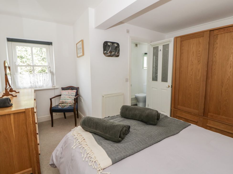 A bedroom with a bed and a chair at Awen Ingli Newport, Pembrokeshire