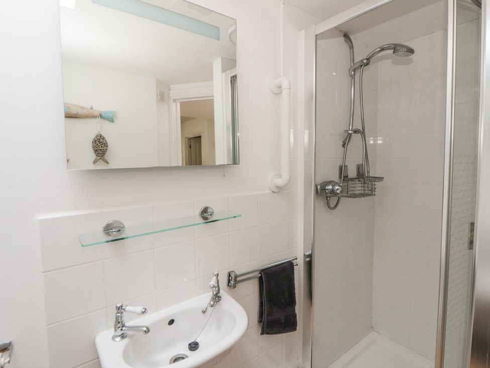 A bathroom with a shower and wash basin at Awen Ingli, Newport, Pembrokeshire
