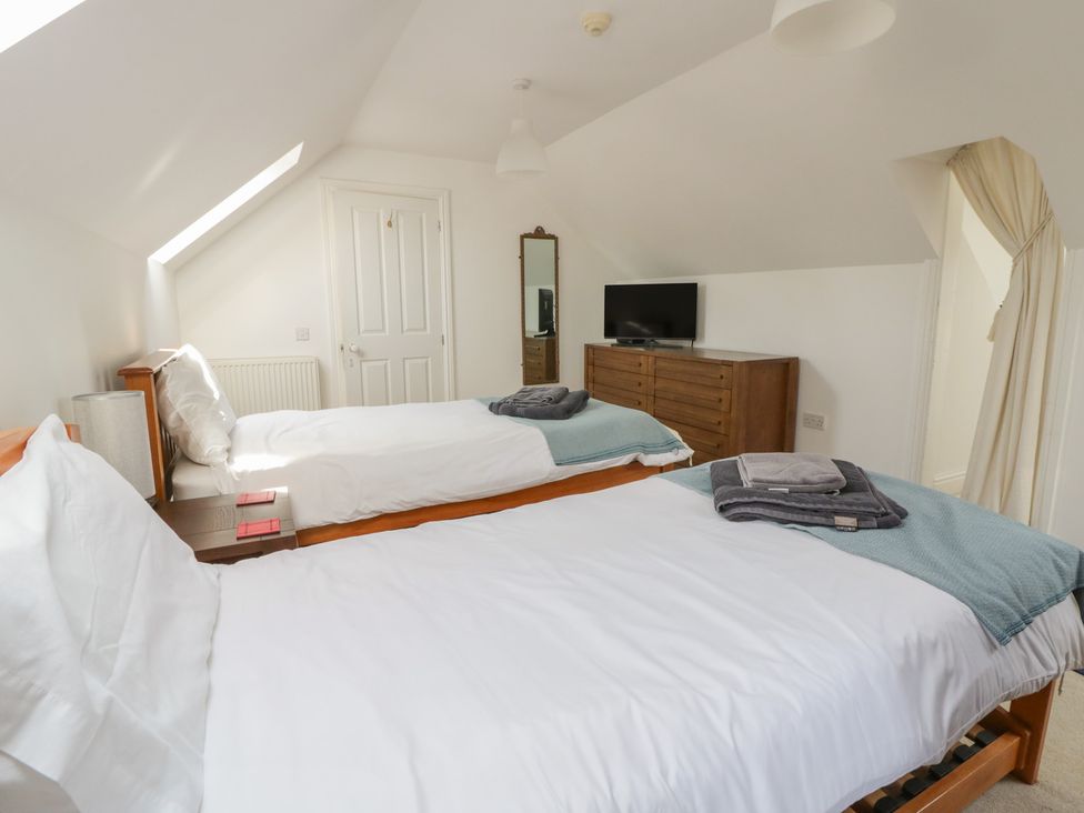 A bedroom with two beds and a television at Awen Ingli in Newport, Pembrokeshire