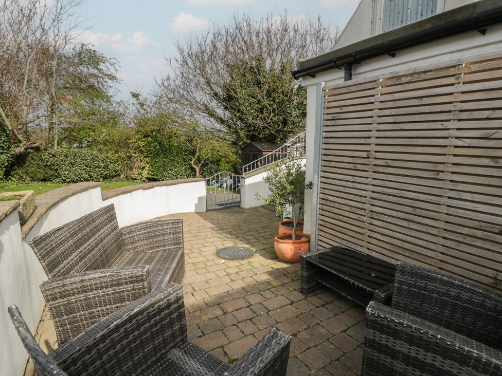 A garden with wicker chairs and a table at Awen Ingli, Newport, Pembrokeshire