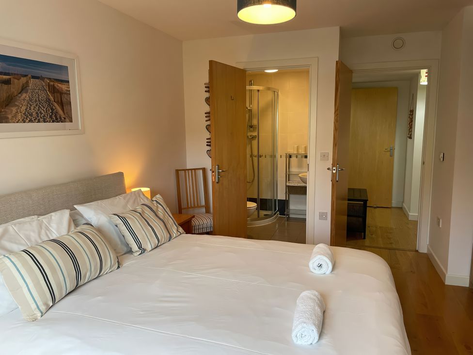 A bedroom with a bed and a bathroom at Broadleys in Swanage