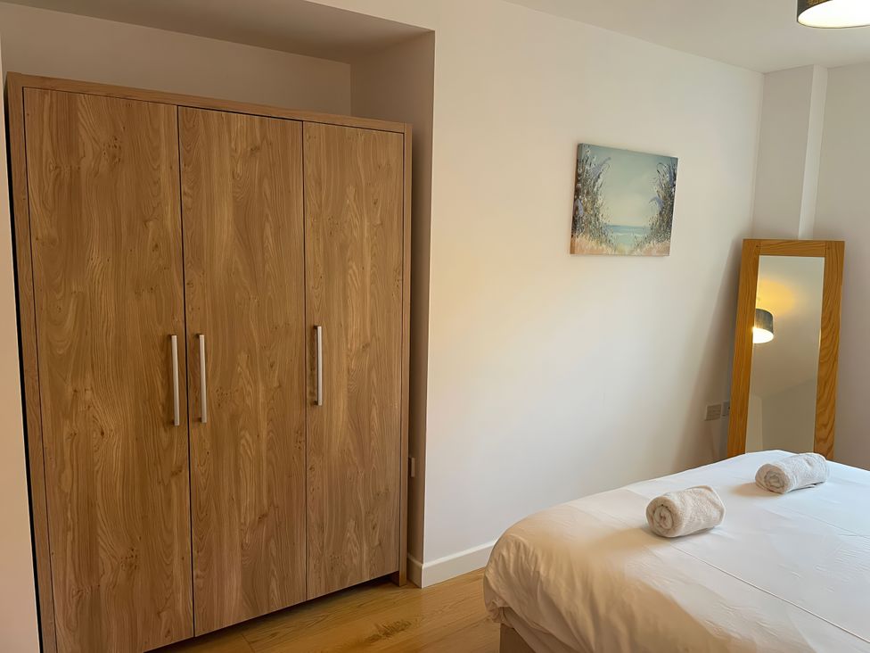 A bedroom with a bed and wardrobe at Broadleys in Swanage