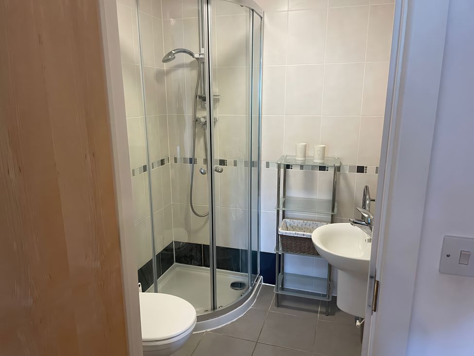 A bathroom with a shower, toilet, and sink at Broadleys in Swanage