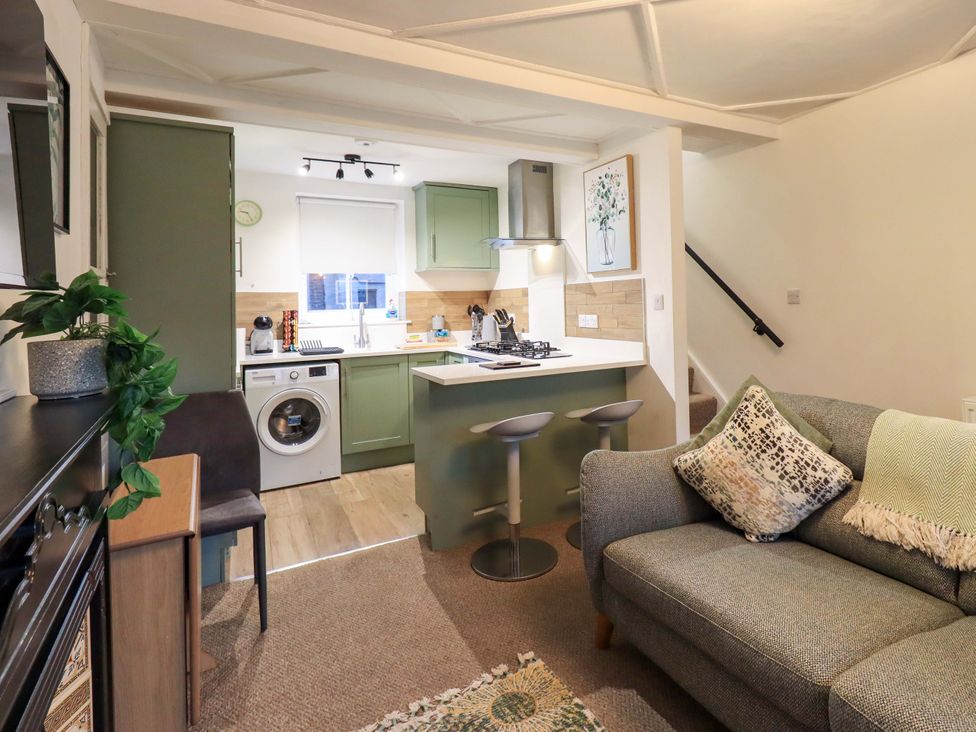 A kitchen with a sofa and bar stools at 21 Entry Lane Kendal