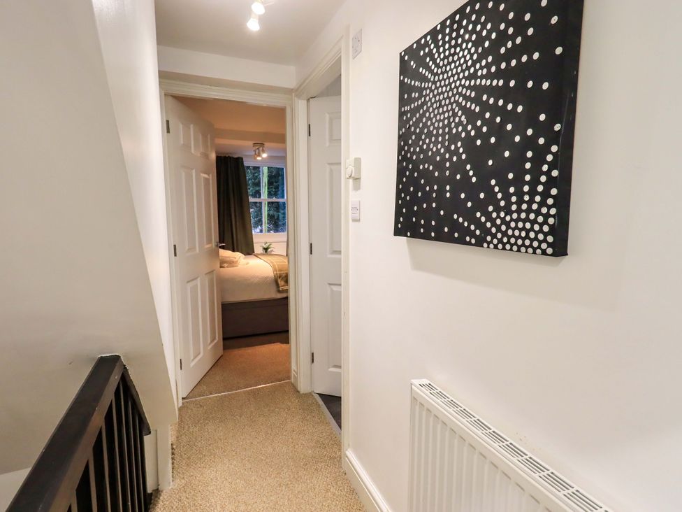 A hallway with doors and wall art at 21 Entry Lane Kendal