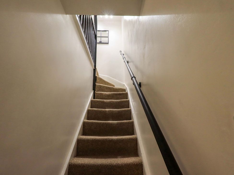 A staircase with carpeted steps and a handrail at 21 Entry Lane, Kendal