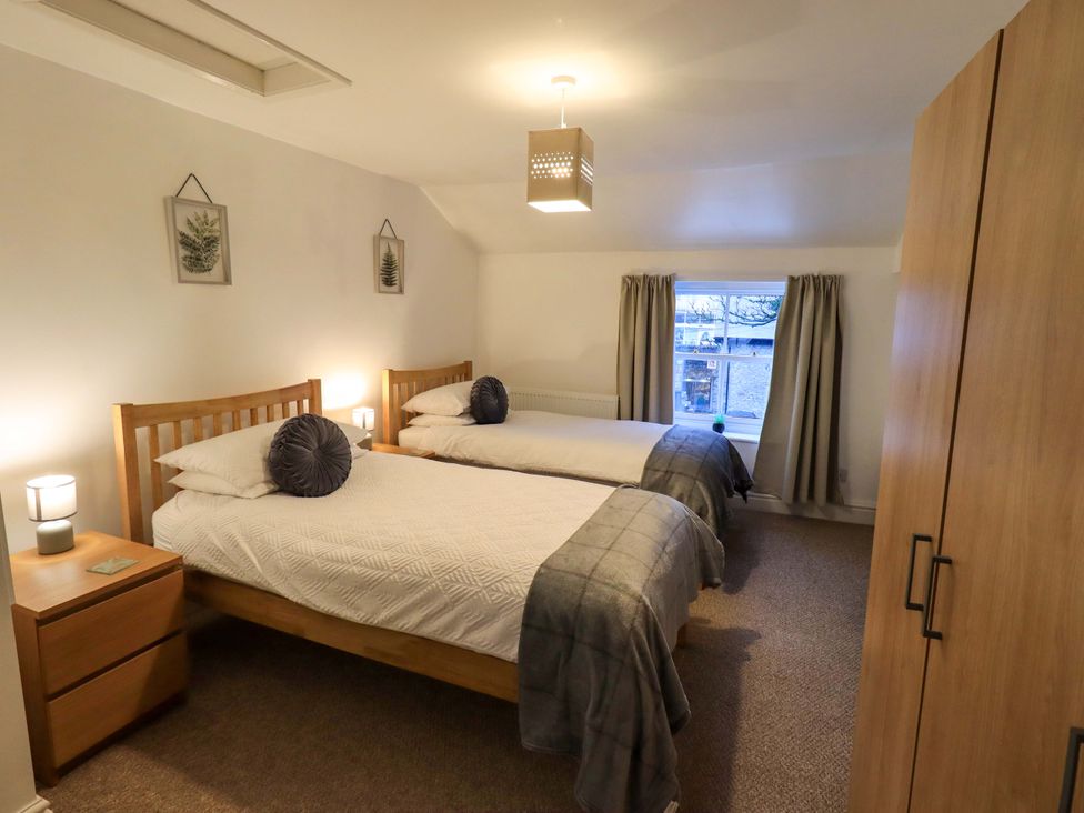 A bedroom with two beds and a wardrobe at 21 Entry Lane, Kendal