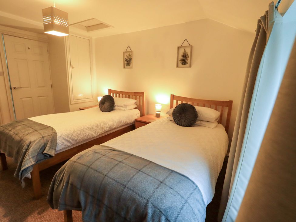 A bedroom with two single beds and a nightstand at 21 Entry Lane in Kendal