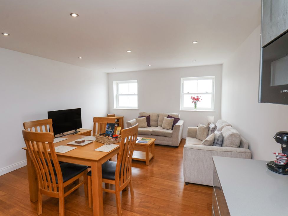 A living room with a dining table and sofa at Sandsend View in Whitby