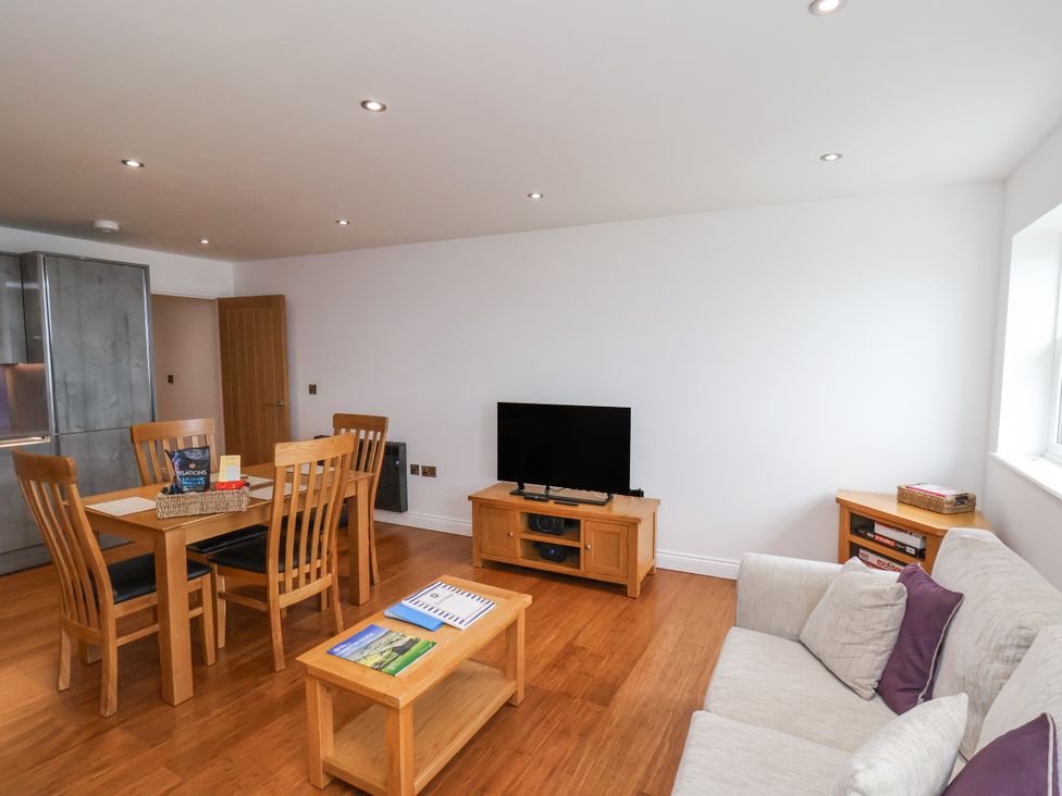 A living room with a sofa and dining area at Sandsend View in Whitby