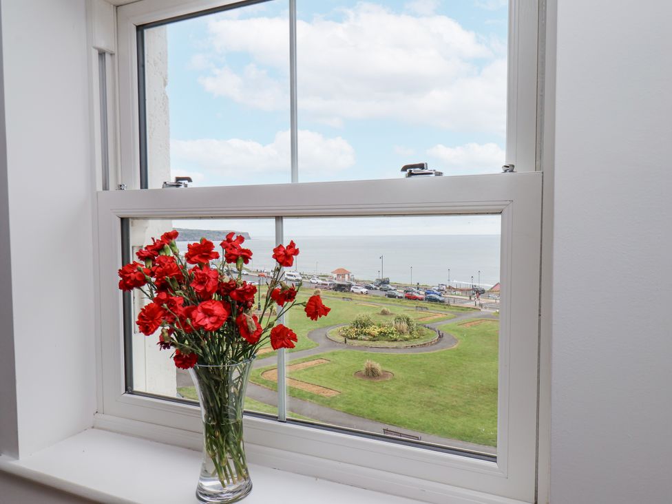 A window with flowers and a sea view at Sandsend View in Whitby