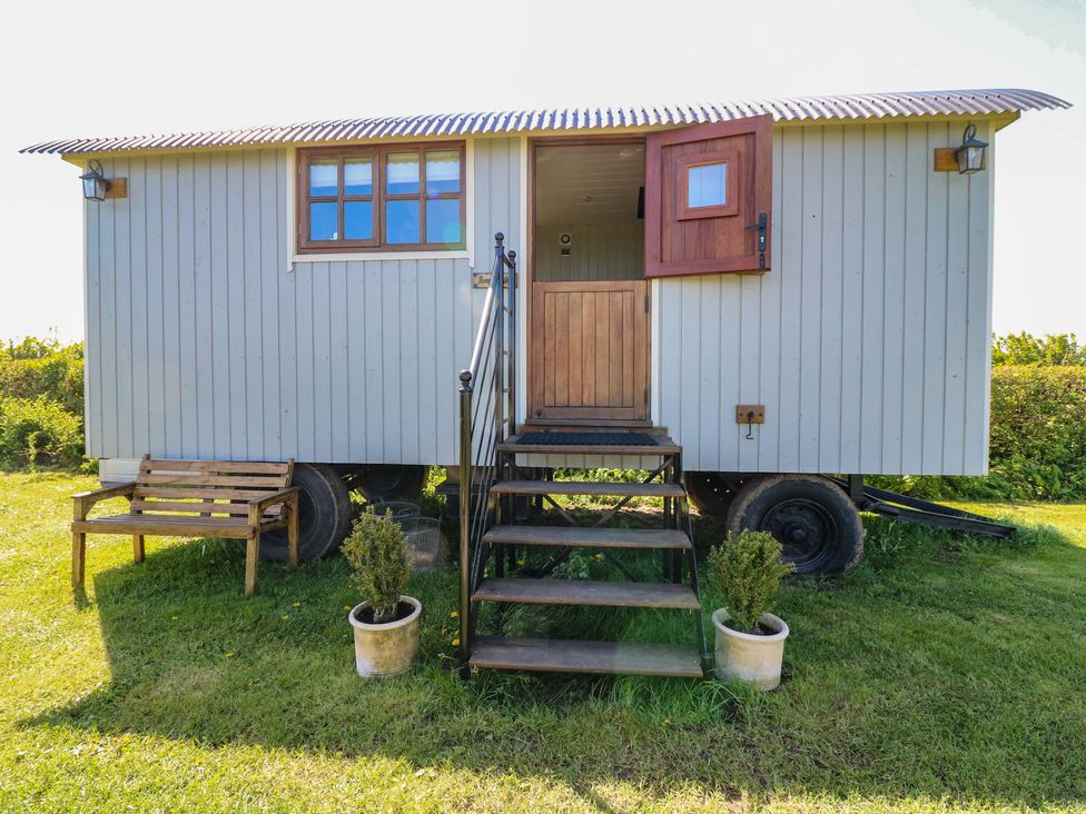 A shepherd's hut with stairs and a bench at Sweet Caroline Shepherd’s Hut in Low Marnham near Sutton-On-Trent