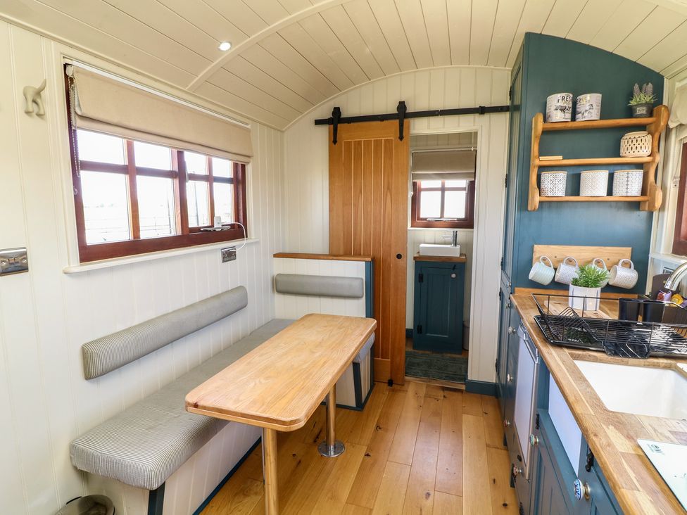 A kitchen with seating space and cabinets at Sweet Caroline Shepherd’s Hut Low Marnham near Sutton-On-Trent