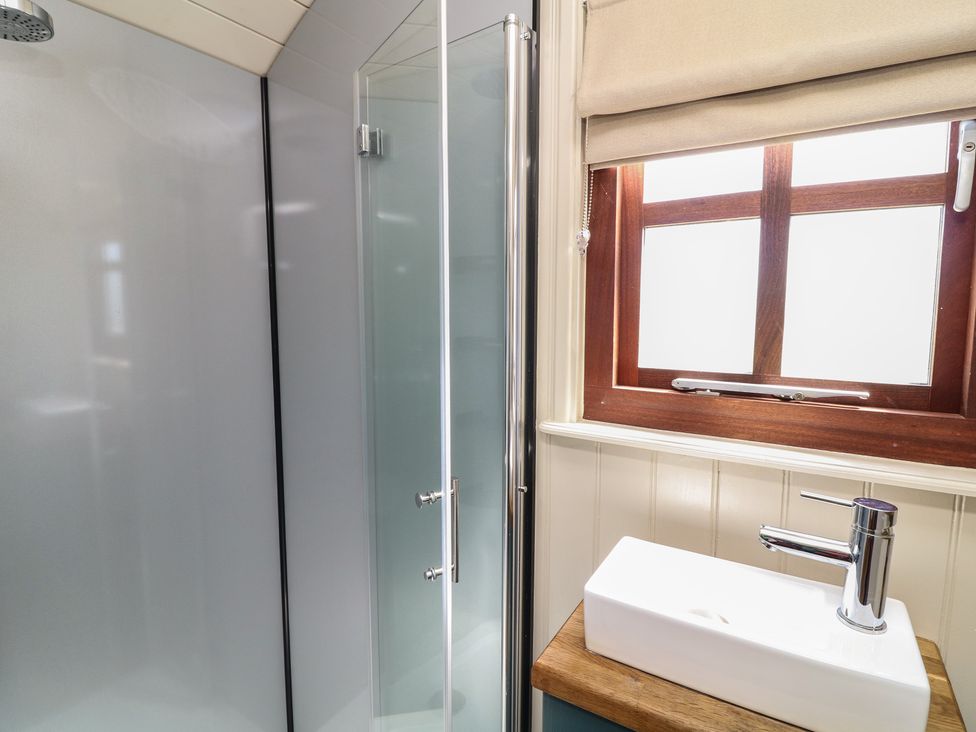 A bathroom with a shower and sink at Sweet Caroline Shepherd’s Hut Low Marnham near Sutton-On-Trent