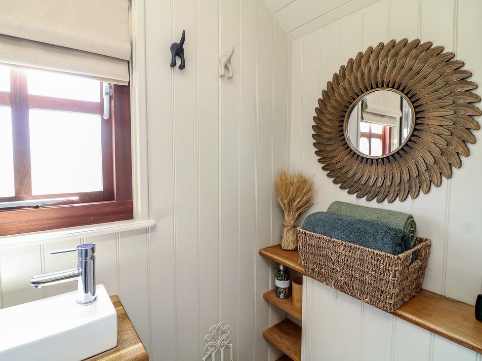 A bathroom with a sink and mirror at Sweet Caroline Shepherd’s Hut in Low Marnham near Sutton-On-Trent